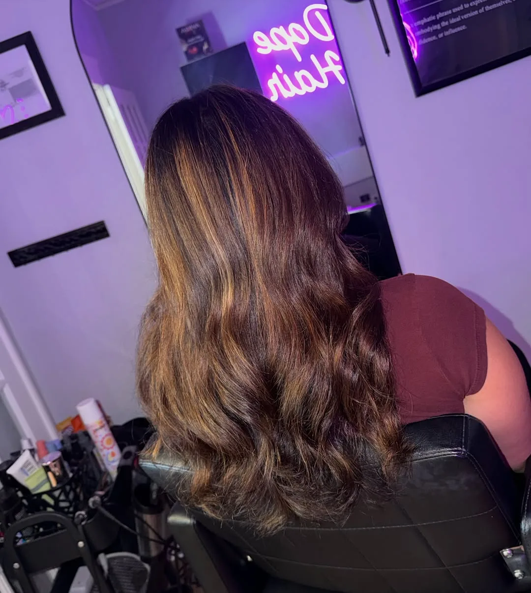 Long brunette hair with soft dimensional lightness and loose waves, photographed from behind at Salon W