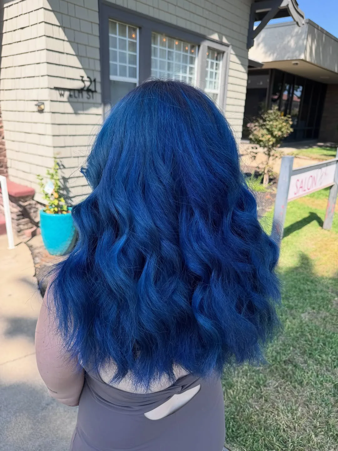 Long wavy hair in vivid saturated blue, photographed from behind outside Salon W in Lodi